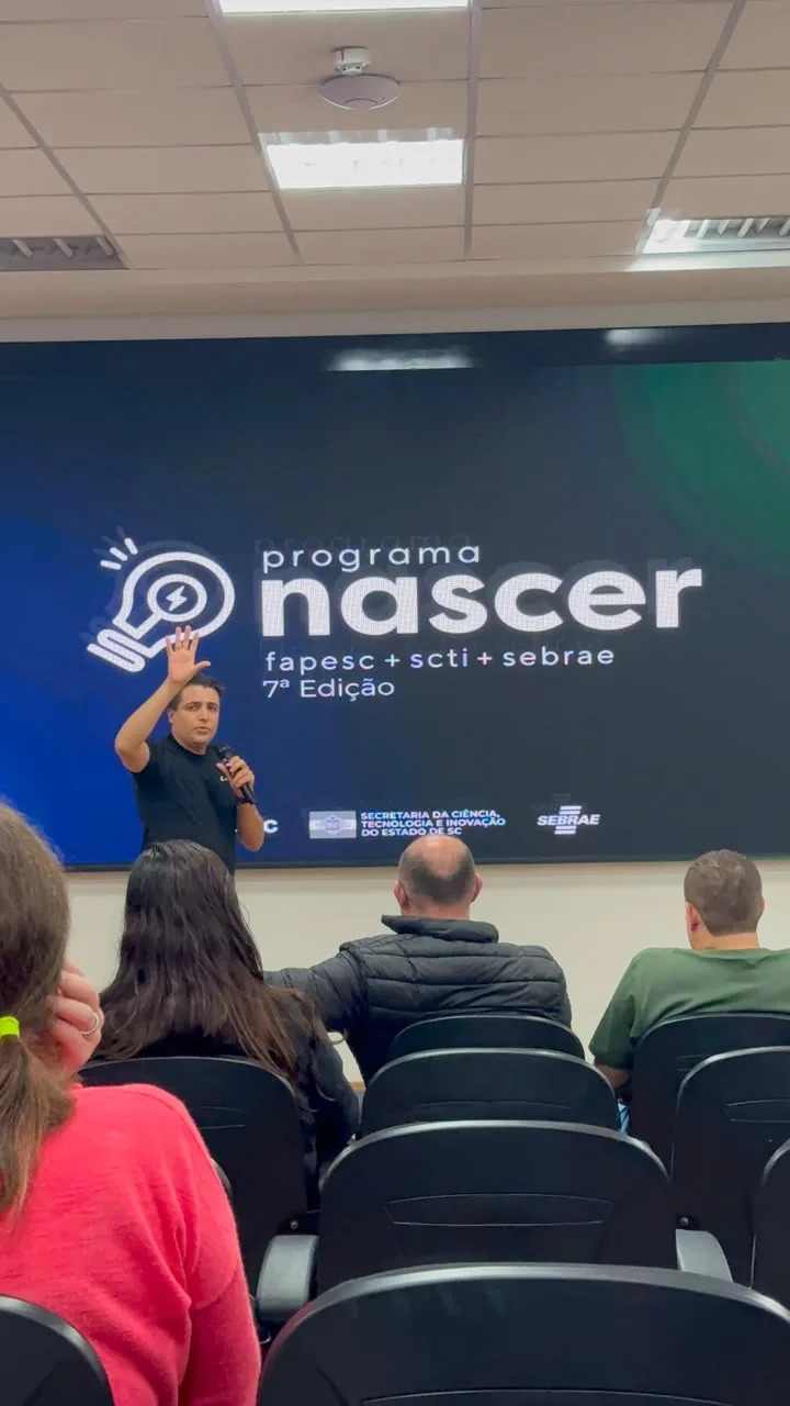 Michael Salomon apresentando pitch no palco do Programa Nascer, com o telão do programa ao fundo