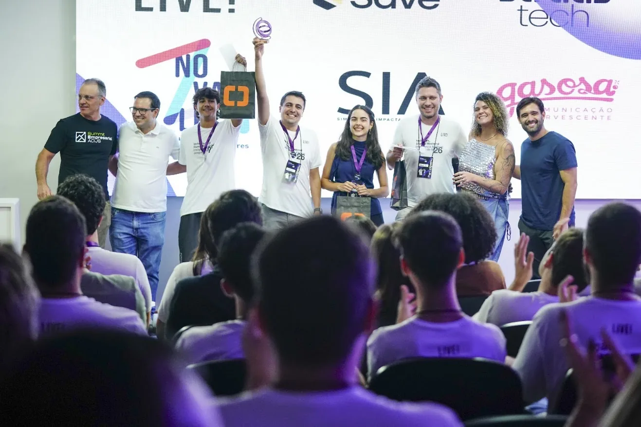 Michael Salomon e equipe recebendo o troféu de 1º lugar no palco do Techstars Startup Weekend de Inteligência Artificial